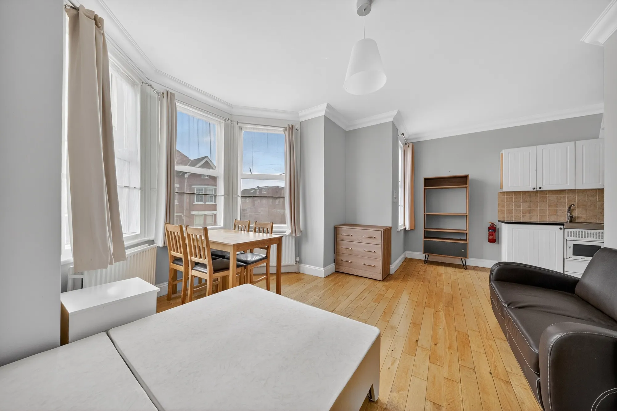 Spacious resident studio room with double bed, seating area and private kitchenette at Pinfold Care Home