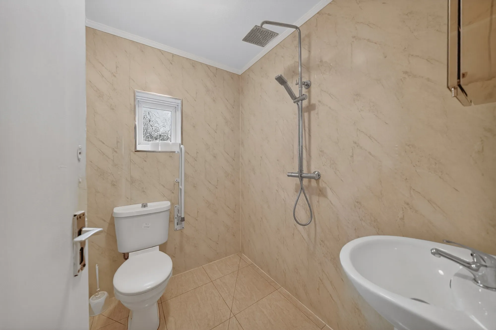 Modern accessible shower room with walk-in shower and support rail at Pinfold Care Home